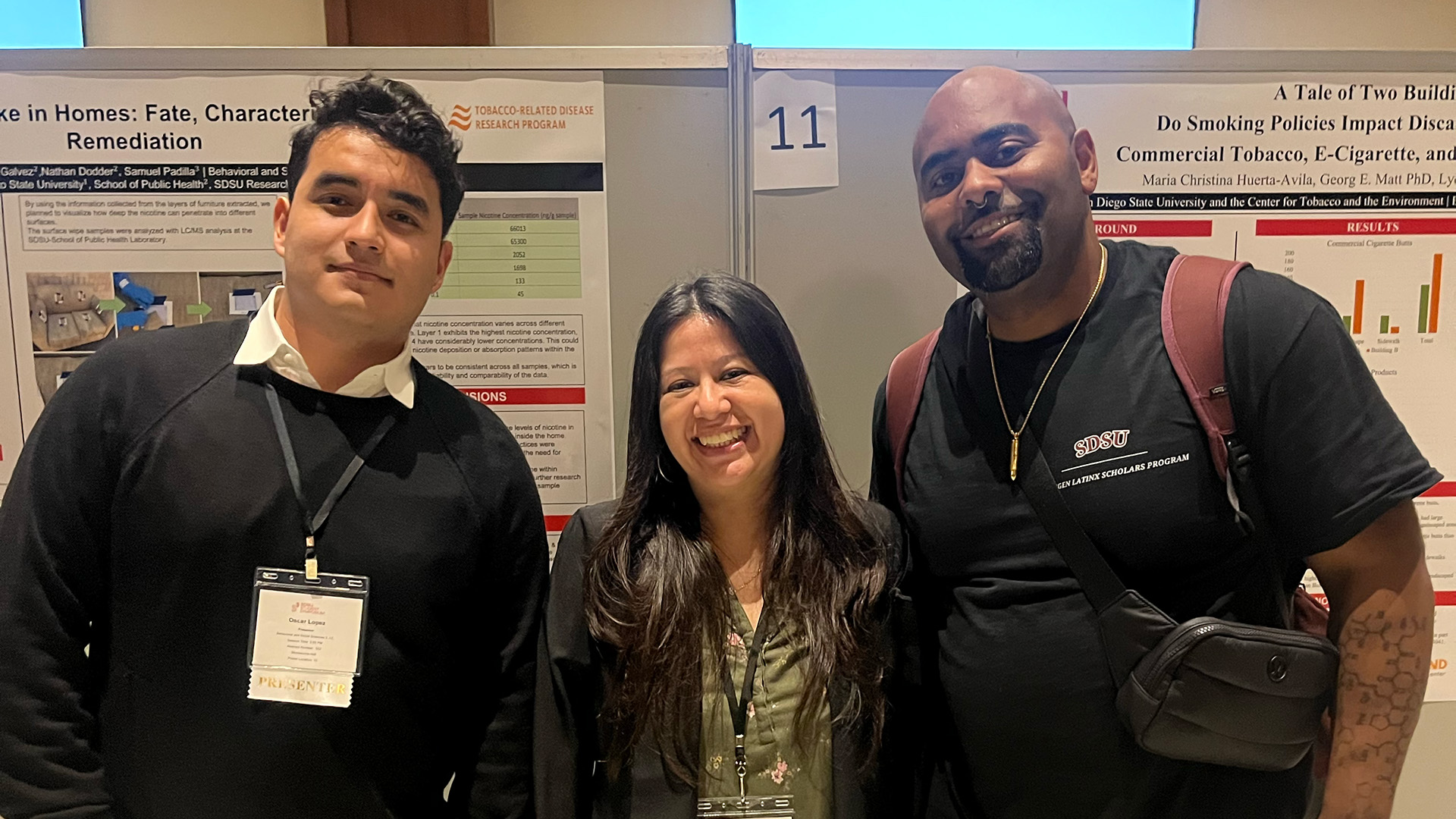 Oscar Lopez Vazquez, Maria Christina Huerta-Avila , and Andy Jose Lopez with research posters in background.